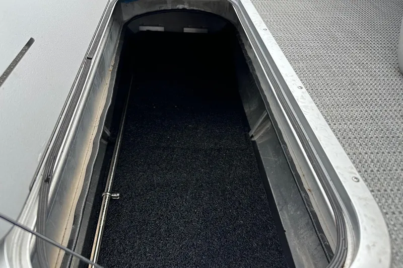 Slide: The Image of Storage compartment of 2024 Bennington LX Sport Line boat, featuring carpeted interior and metal trim. - 28