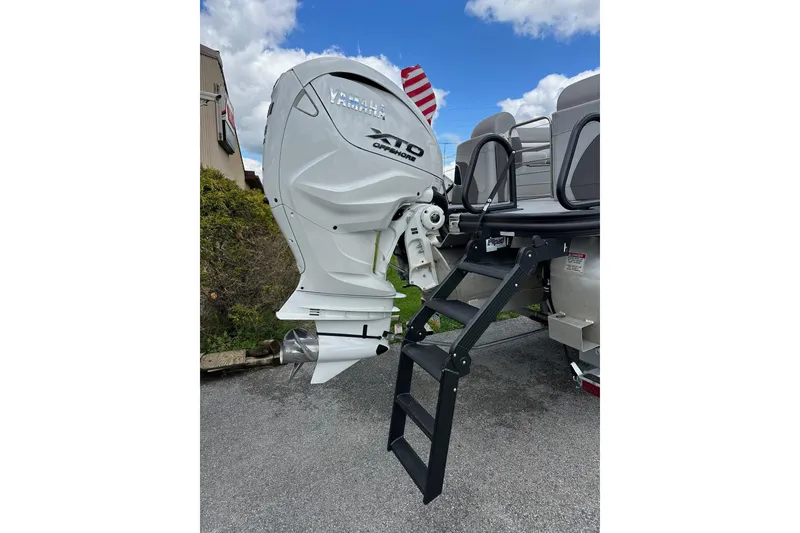 Slide: The Image of 2024 Bennington LX Sport Line boat with Yamaha outboard motor and boarding ladder. - 34
