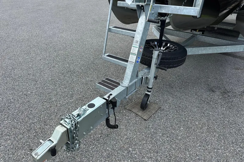 Slide: The Image of Trailer hitch and wheel assembly of 2024 Bennington LX Sport Line on asphalt. - 36