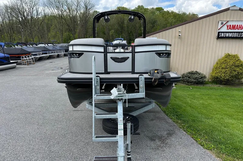 Slide: The Image of 2024 Bennington LX Sport Line pontoon boat on trailer, parked near Yamaha dealership. - 6