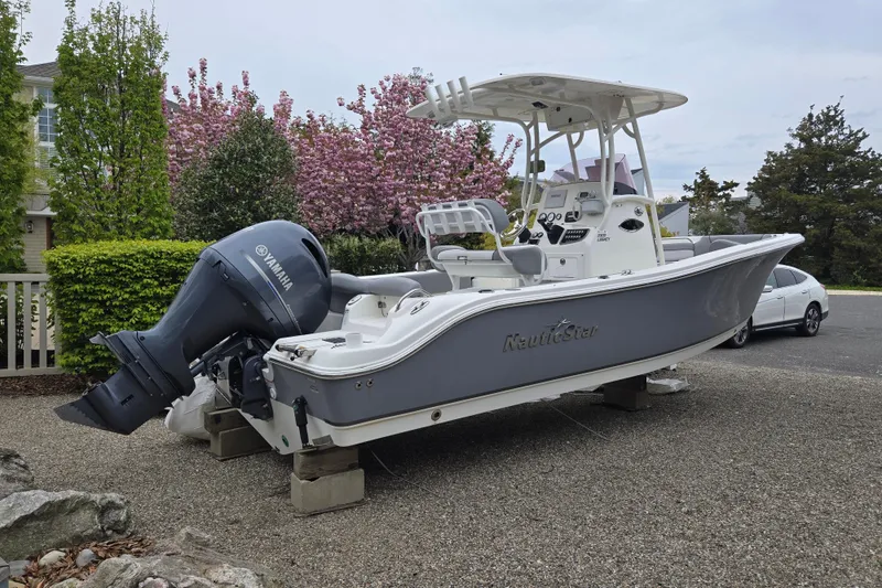 The Image of 2021 NauticStar 2302 Legacy boat with Yamaha engine on display outdoors. - 0