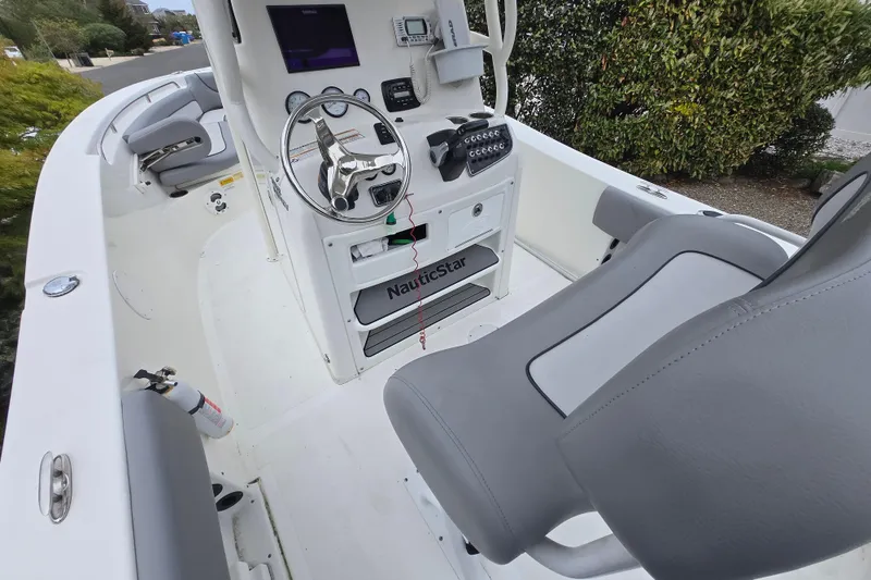 Slide: The Image of 2021 NauticStar 2302 Legacy boat interior with steering wheel and seating. - 10