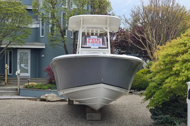 Slide: The Image of 2021 NauticStar 2302 Legacy boat for sale, displayed on a gravel driveway. - 15