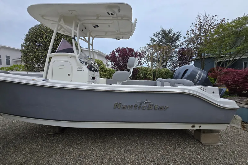Slide: The Image of 2021 NauticStar 2302 Legacy boat on display, featuring sleek design and Yamaha engine. - 16