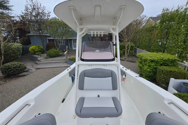 Slide: The Image of 2021 NauticStar 2302 Legacy boat with seating, parked in a landscaped area. - 18
