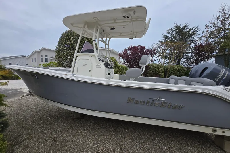 Slide: The Image of 2021 NauticStar 2302 Legacy boat on display, featuring sleek design and Yamaha engine. - 19