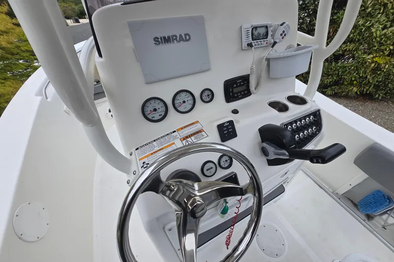Slide: The Image of 2021 NauticStar 2302 Legacy boat dashboard with steering wheel and control panel. - 4