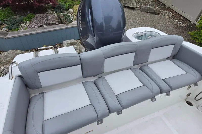 Slide: The Image of 2021 NauticStar 2302 Legacy boat with gray and white cushioned seating. - 6