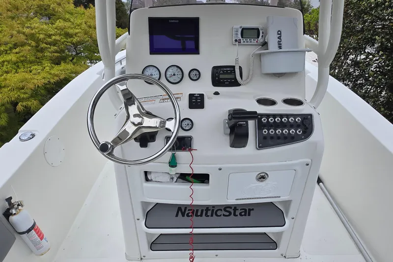 Slide: The Image of 2021 NauticStar 2302 Legacy boat console with steering wheel and navigation controls. - 7