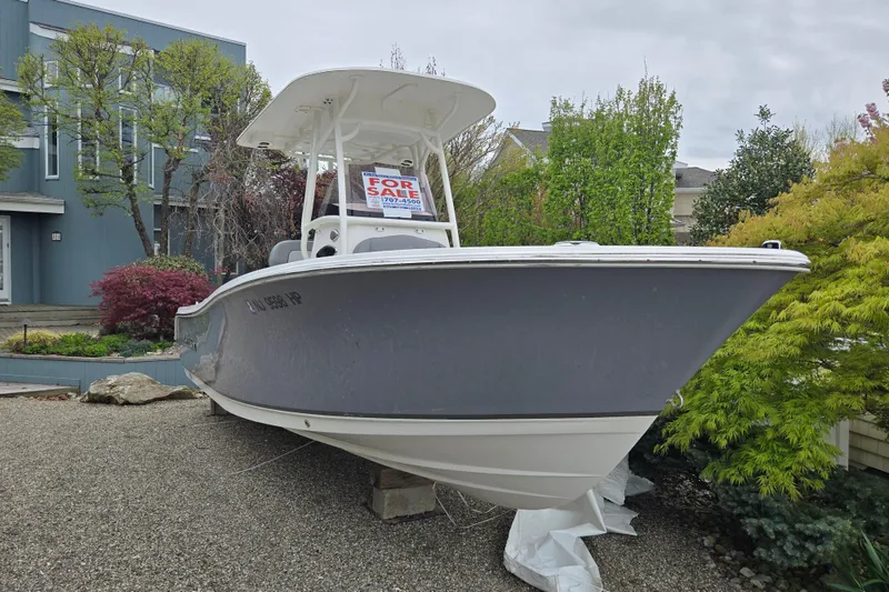 Slide: The Image of 2021 NauticStar 2302 Legacy boat for sale, displayed on gravel with greenery background. - 8