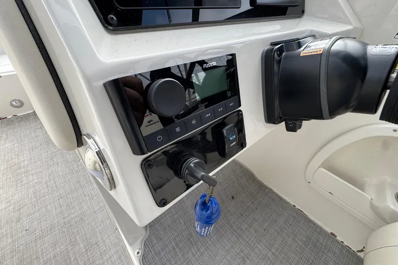 Slide: The Image of 2024 Stingray 211 DC boat dashboard with Fusion audio system and ignition key. - 11