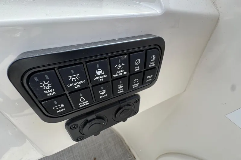Slide: The Image of Control panel of 2024 Stingray 211 DC boat with various switches and functions. - 12