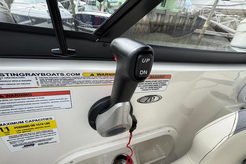 Slide: The Image of Throttle control lever on 2024 Stingray 211 DC boat, with warning labels and capacity information. - 13