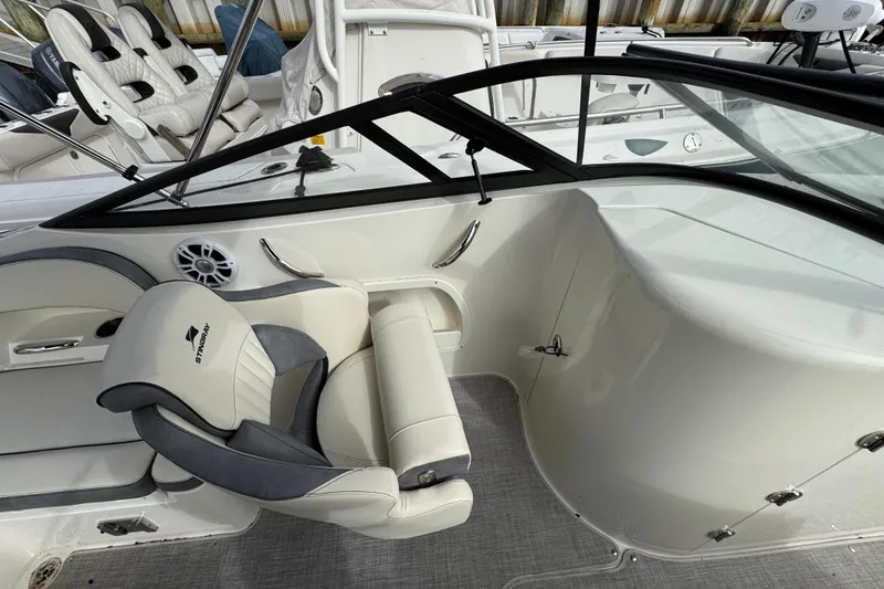 Slide: The Image of 2024 Stingray 211 DC boat interior with seating and steering area. - 14