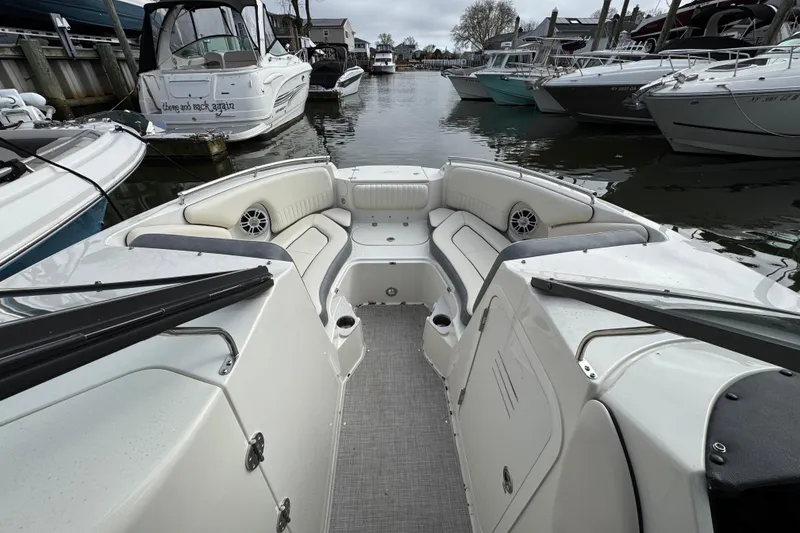 Slide: The Image of 2024 Stingray 211 DC boat interior with seating, docked among other boats. - 16