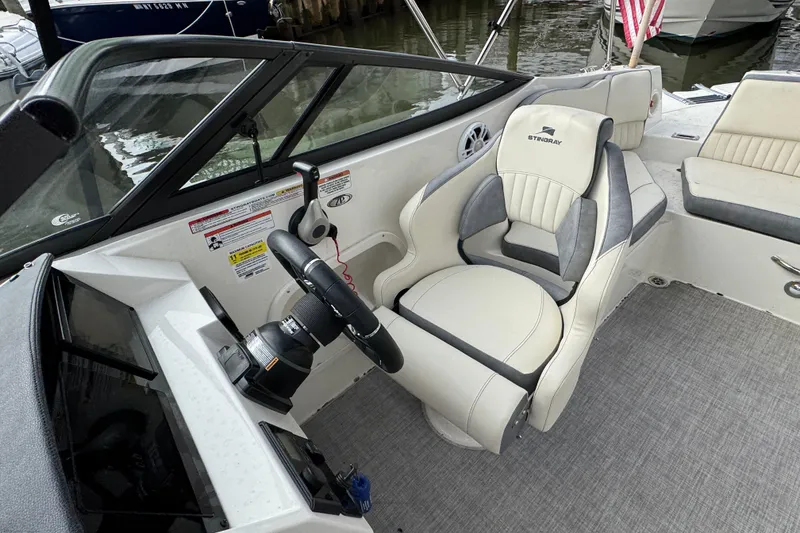 Slide: The Image of 2024 Stingray 211 DC boat interior with steering wheel and comfortable seating. - 24