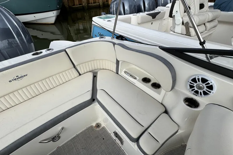 Slide: The Image of 2024 Stingray 211 DC boat interior with cushioned seating and speaker system. - 26