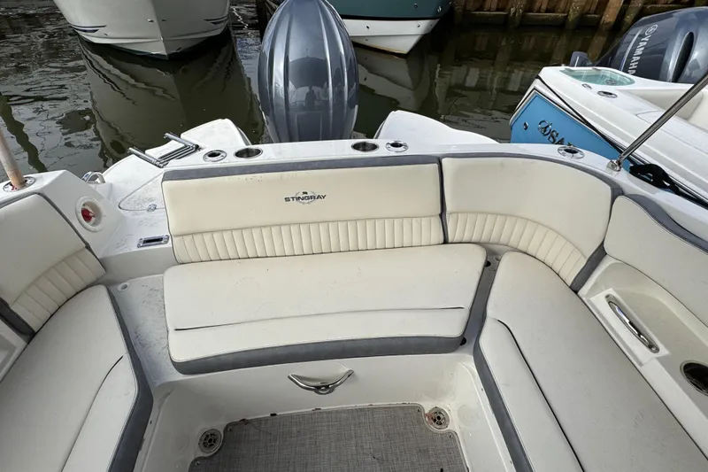 Slide: The Image of 2024 Stingray 211 DC boat interior with white seating and cup holders. - 27