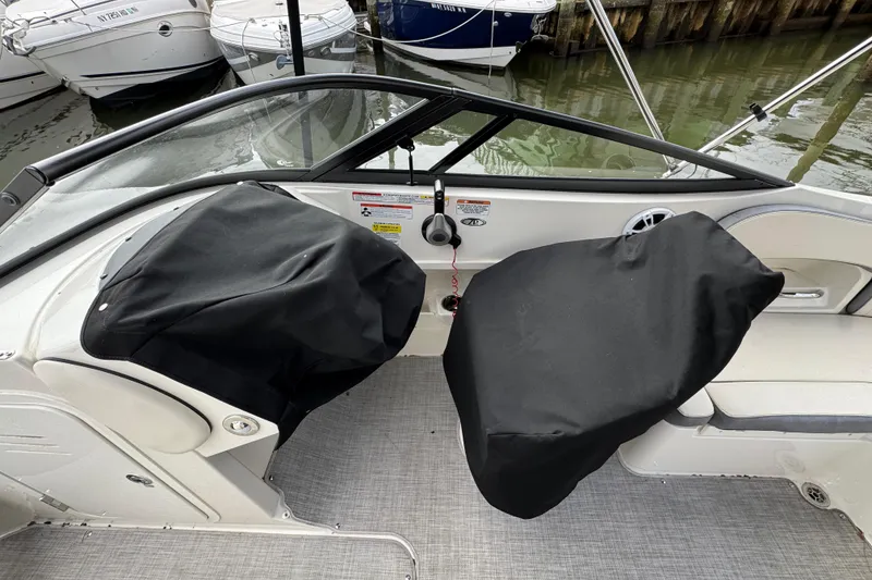 Slide: The Image of 2024 Stingray 211 DC boat interior with covered seats at a marina. - 29