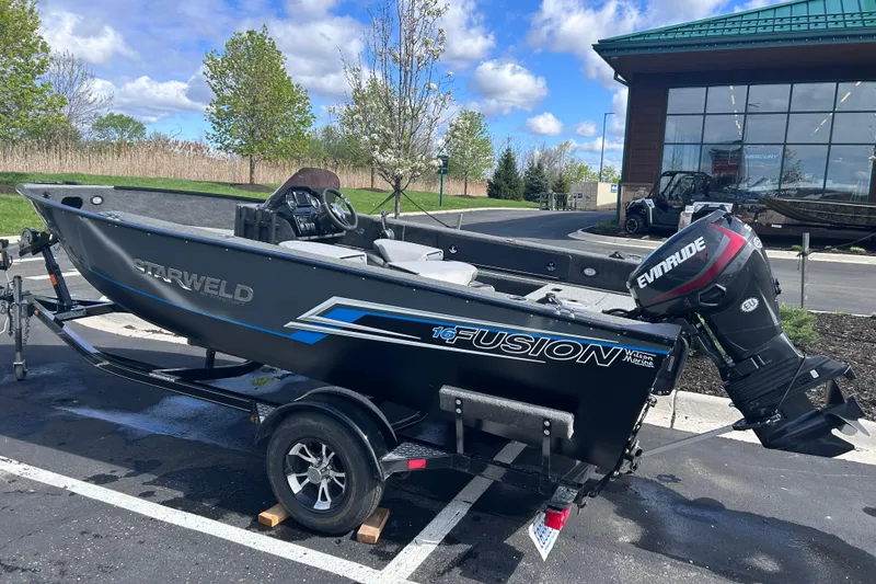 Slide: The Image of 2019 Starweld Fusion Pro 16 SC boat with Evinrude motor on trailer, parked outdoors. - 2