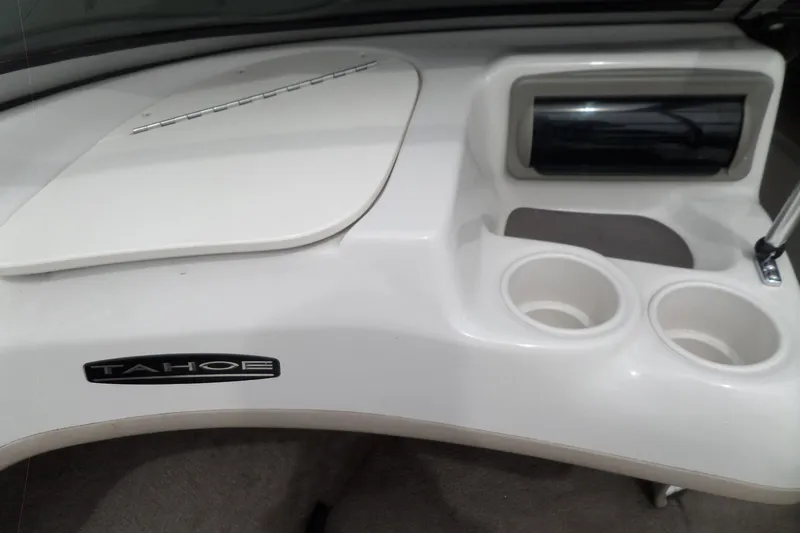 Slide: The Image of 2005 Tahoe Q4 Sport boat dashboard with cup holders and storage compartment. - 17
