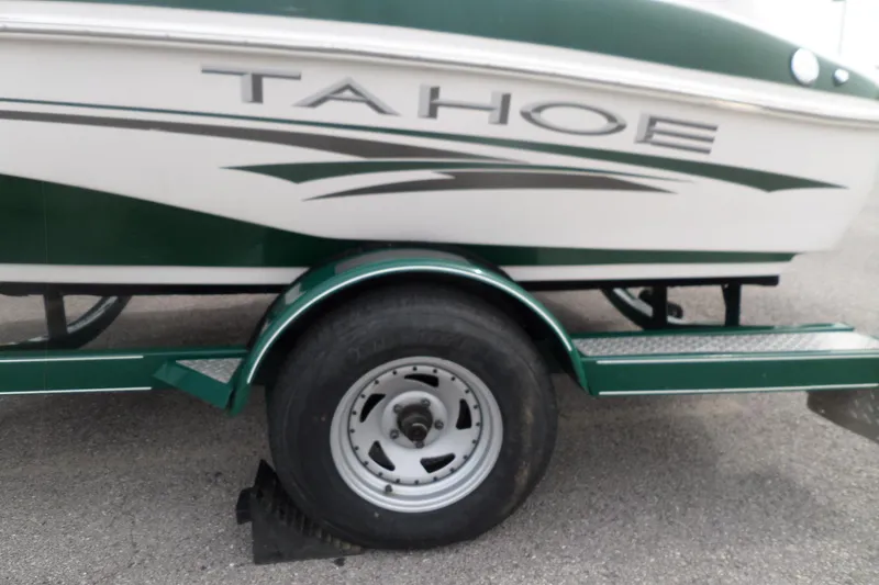 Slide: The Image of 2005 Tahoe Q4 Sport boat on trailer, green and white design. - 5
