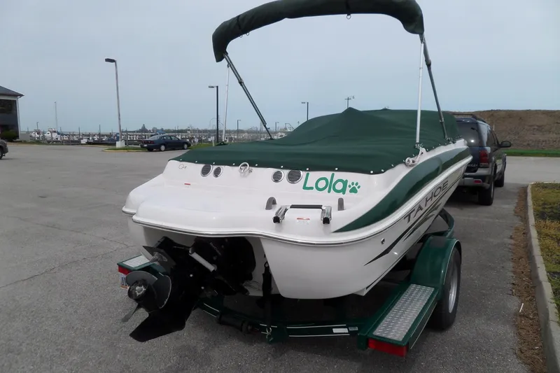 Slide: The Image of 2005 Tahoe Q4 Sport boat on trailer with green cover in parking lot. - 9