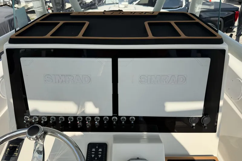 Slide: The Image of 2021 Sea Born LX24 Center Console dashboard with dual Simrad displays and control panel. - 13