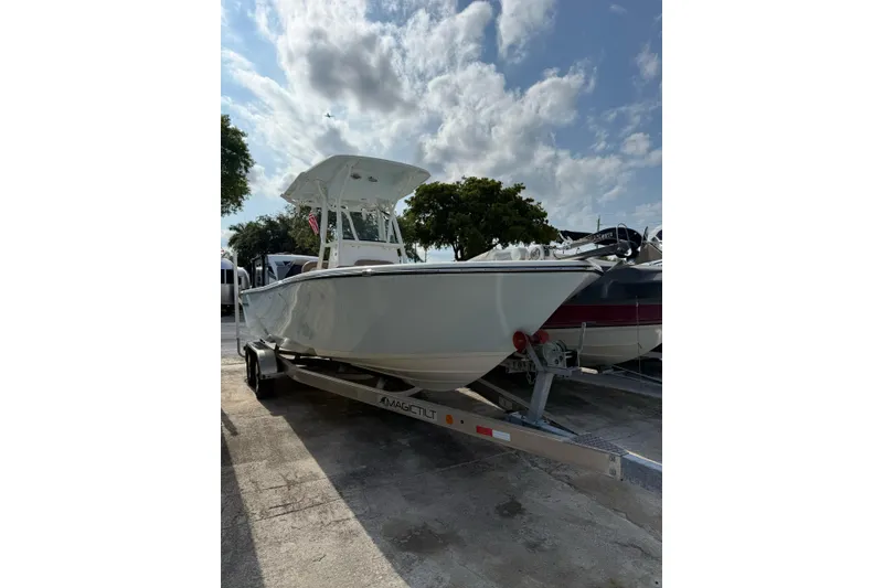 Slide: The Image of 2021 Sea Born LX24 Center Console boat on trailer under cloudy sky. - 2