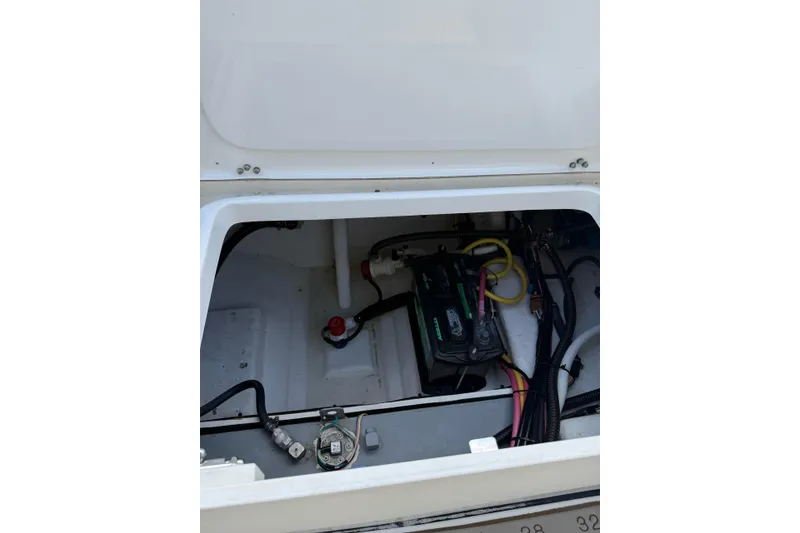 Slide: The Image of 2021 Sea Born LX24 Center Console boat battery compartment with wiring and components. - 24