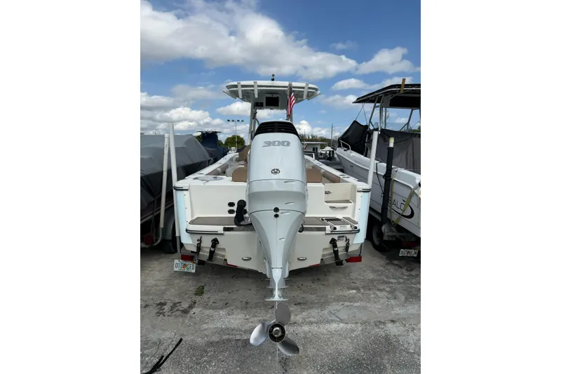 Slide: The Image of 2021 Sea Born LX24 Center Console boat with powerful outboard motor, docked under blue sky. - 5