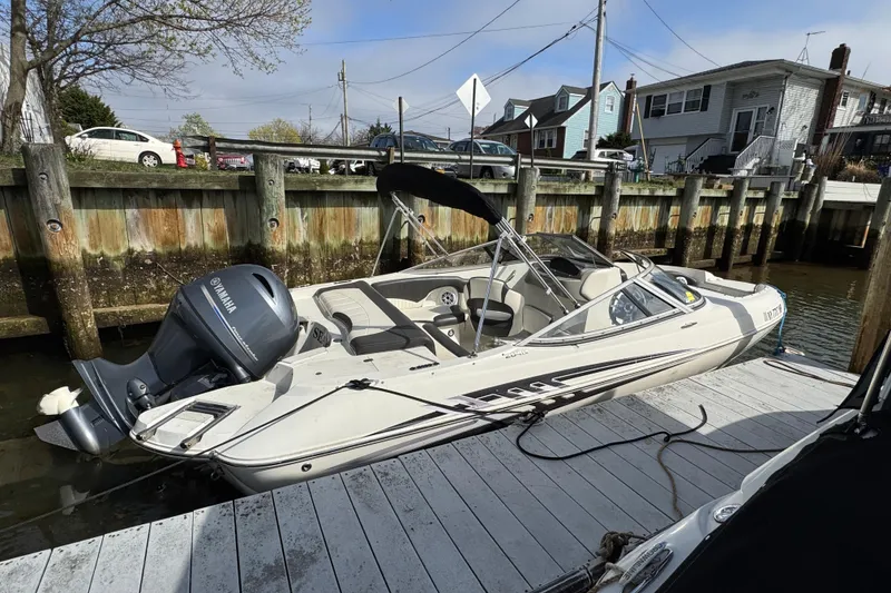 The Image of 2019 Stingray 204 LR boat docked, featuring Yamaha outboard motor, in a residential marina setting. - 1