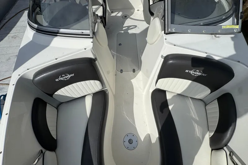 Slide: The Image of 2019 Stingray 204 LR boat interior with black and white seating. - 17