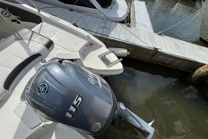 Slide: The Image of 2019 Stingray 204 LR boat with Yamaha 115 engine docked at marina. - 2