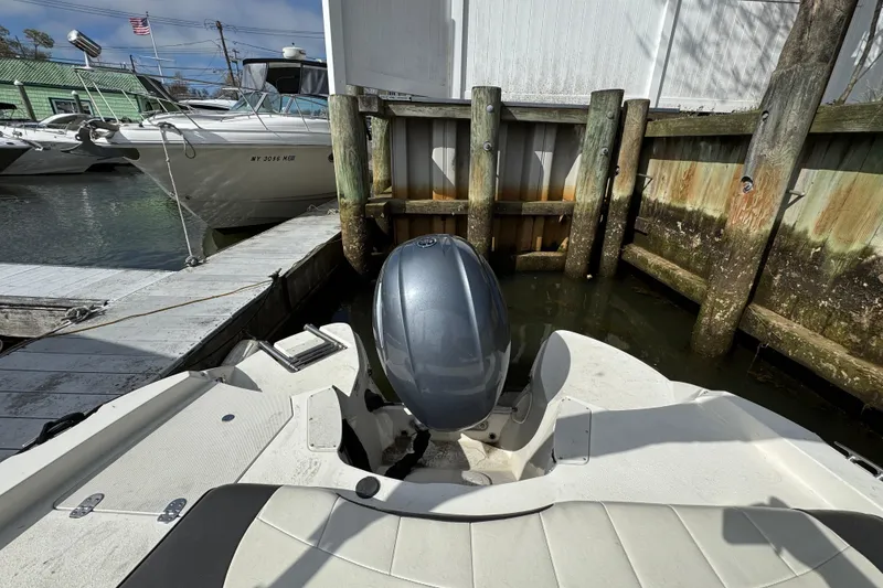 Slide: The Image of 2019 Stingray 204 LR boat docked at marina with outboard motor. - 20