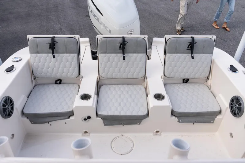Slide: The Image of 2026 Carolina Skiff 24 Ultra Elite boat seating with gray cushions and cup holders. - 13