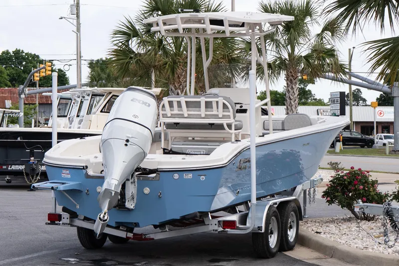 Slide: The Image of 2026 Carolina Skiff 24 Ultra Elite boat on trailer, parked near palm trees. - 5