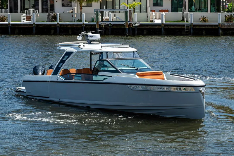 The Image of 2023 Saxdor 320 GTO luxury boat cruising on a sunny waterfront. - 0