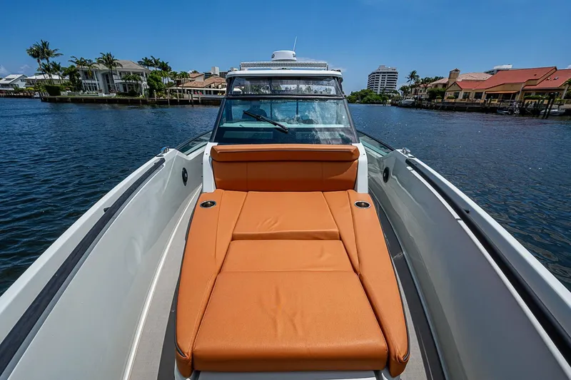 Slide: The Image of 2023 Saxdor 320 GTO boat with orange seating, docked near waterfront homes. - 10