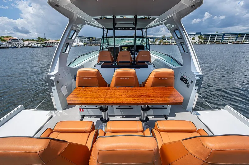 Slide: The Image of 2023 Saxdor 320 GTO boat interior with leather seats and wooden table on a sunny day. - 14