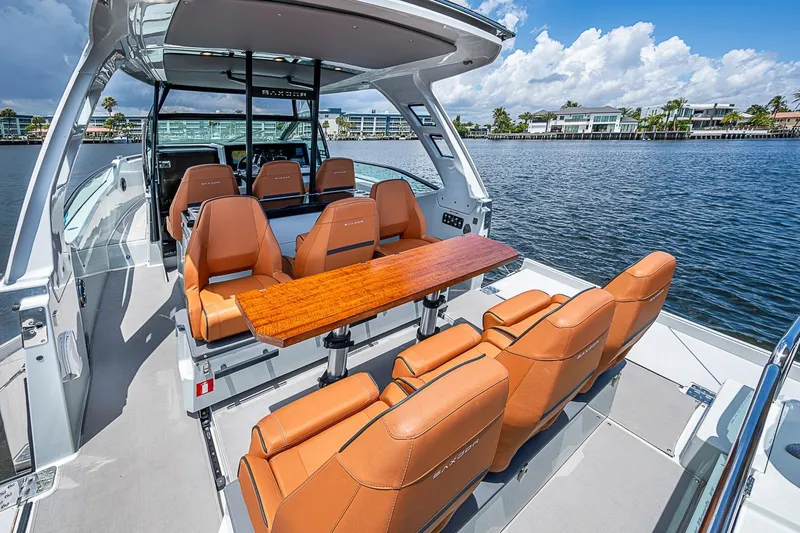 Slide: The Image of 2023 Saxdor 320 GTO boat interior with leather seats and wooden table on water. - 15