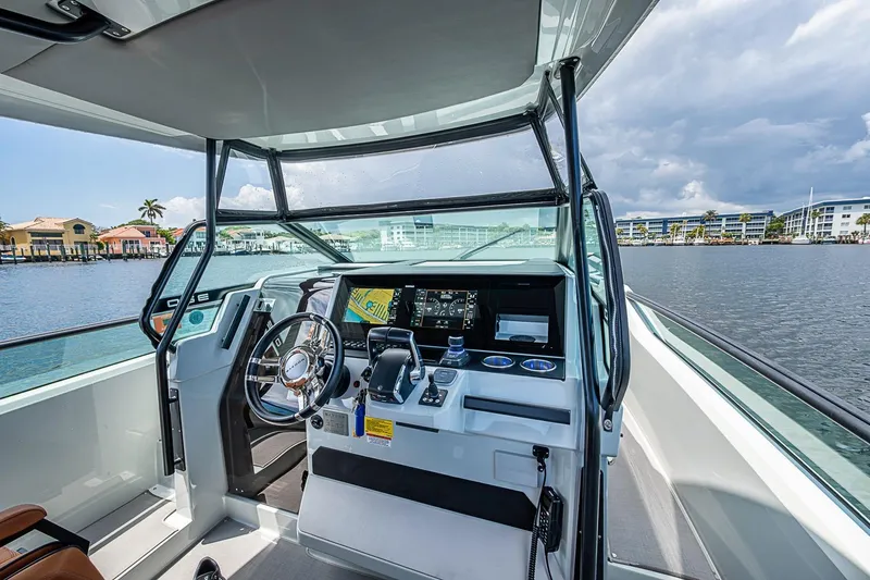 Slide: The Image of 2023 Saxdor 320 GTO helm with modern controls, steering wheel, and waterfront view. - 16