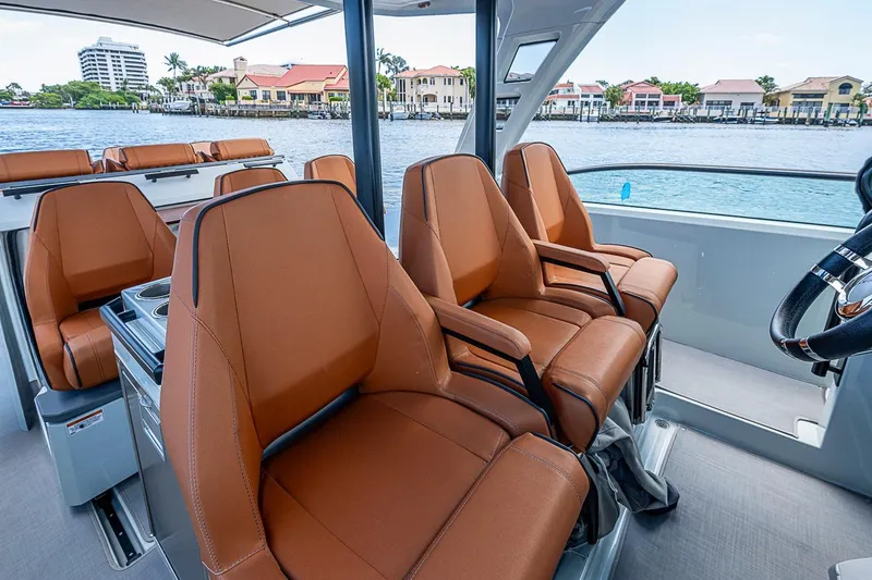 Slide: The Image of 2023 Saxdor 320 GTO boat interior with luxurious brown seating and waterfront view. - 24