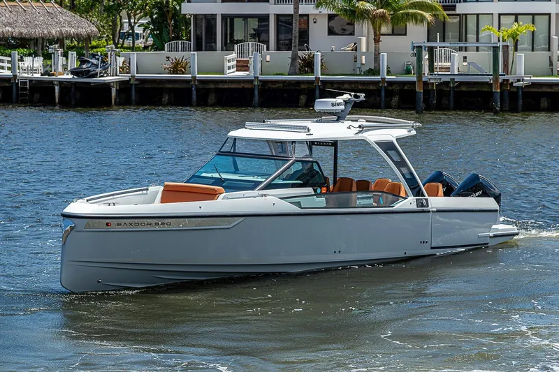Slide: The Image of 2023 Saxdor 320 GTO boat cruising on a sunny waterfront, showcasing sleek design and luxury. - 3