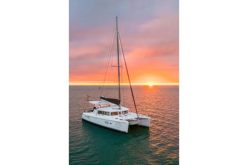 The Image of Lagoon 420 catamaran sailing at sunset, 2008 model, on tranquil ocean waters. - 0