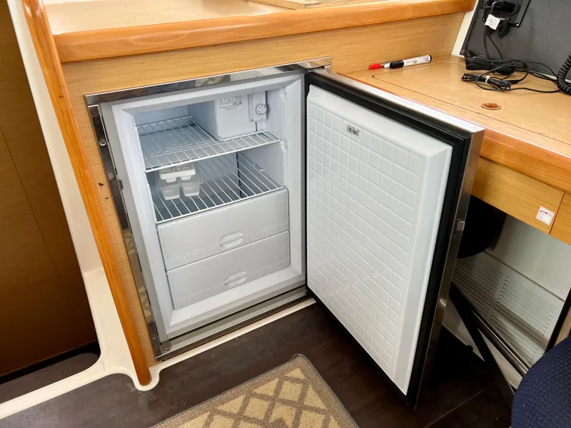 Slide: The Image of Open refrigerator in a 2008 Lagoon 420 yacht interior, showing shelves and drawers. - 18