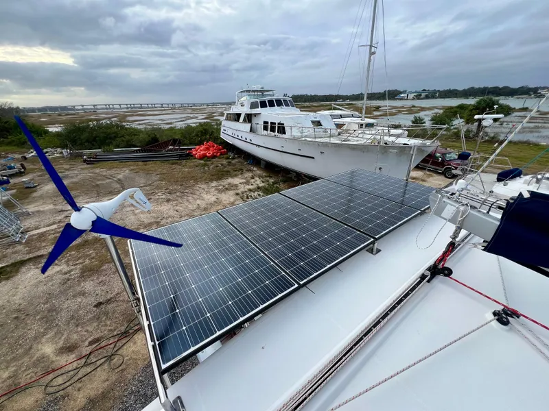 Slide: The Image of Lagoon 420 catamaran with solar panels and wind turbine, docked near other boats, 2008 model. - 23