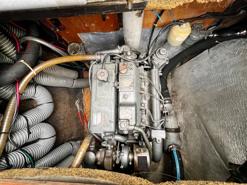 Slide: The Image of Engine compartment of a 2008 Lagoon 420 catamaran, showcasing mechanical components and hoses. - 27