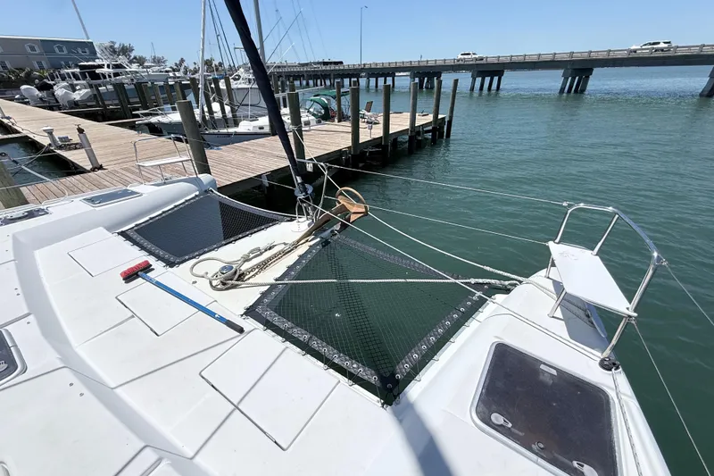 Slide: The Image of 2008 Lagoon 420 catamaran docked at marina with bridge in background. - 31