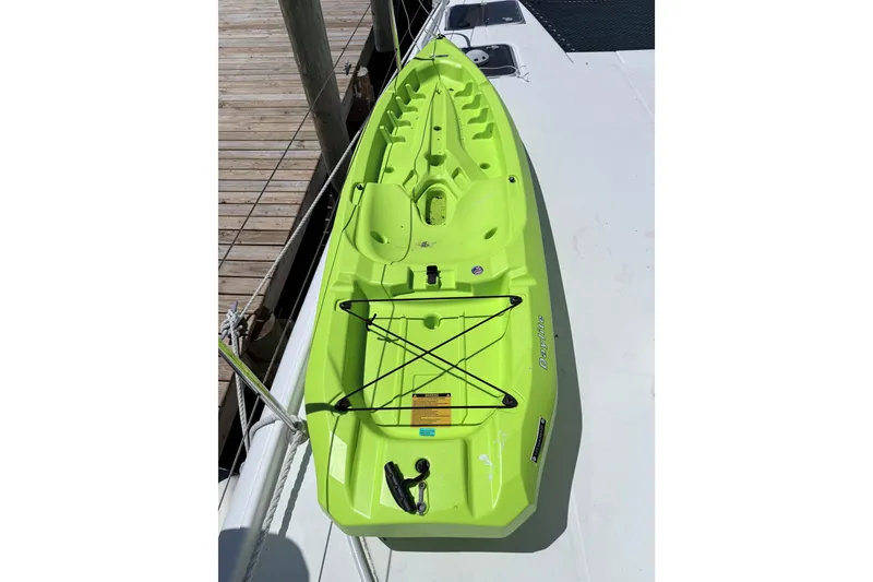 Slide: The Image of Bright green kayak on a Lagoon 420 catamaran, docked at a wooden pier. - 41